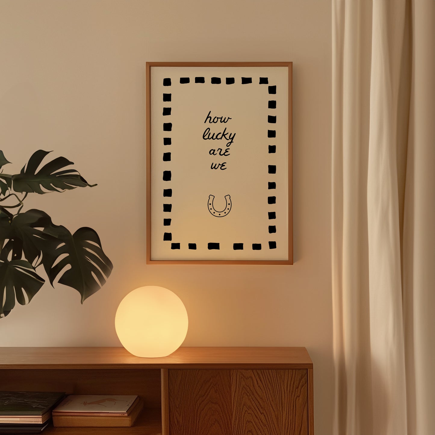 Cream print with a black dashed border featuring the handwritten quote 'how lucky are we' and a horseshoe illustration