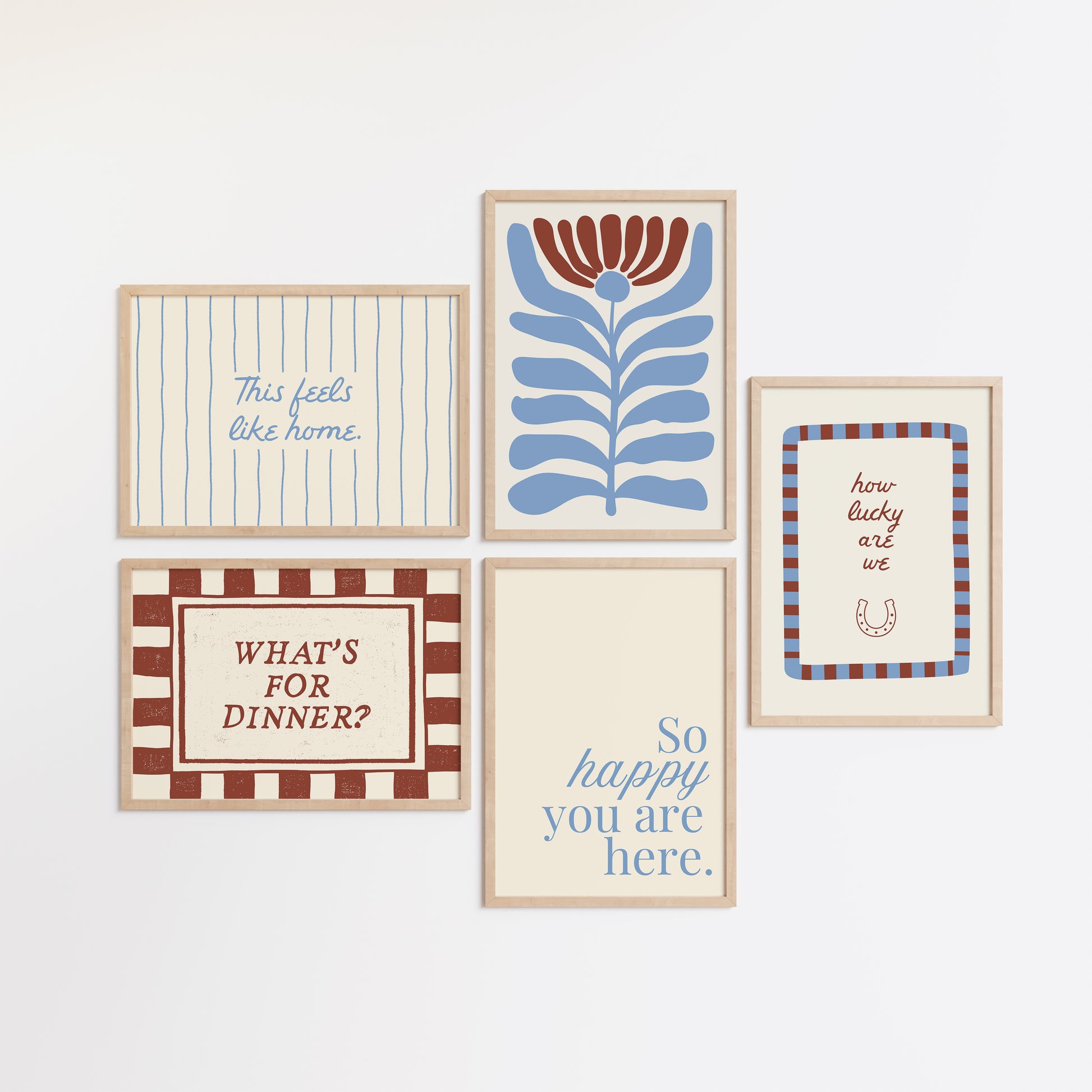 Set of five prints in rust and dusty blue: "How lucky are we" with a horseshoe, "So happy you are here," "What's for dinner?" in a checkered border, "This feels like home" on stripes, and a floral illustration