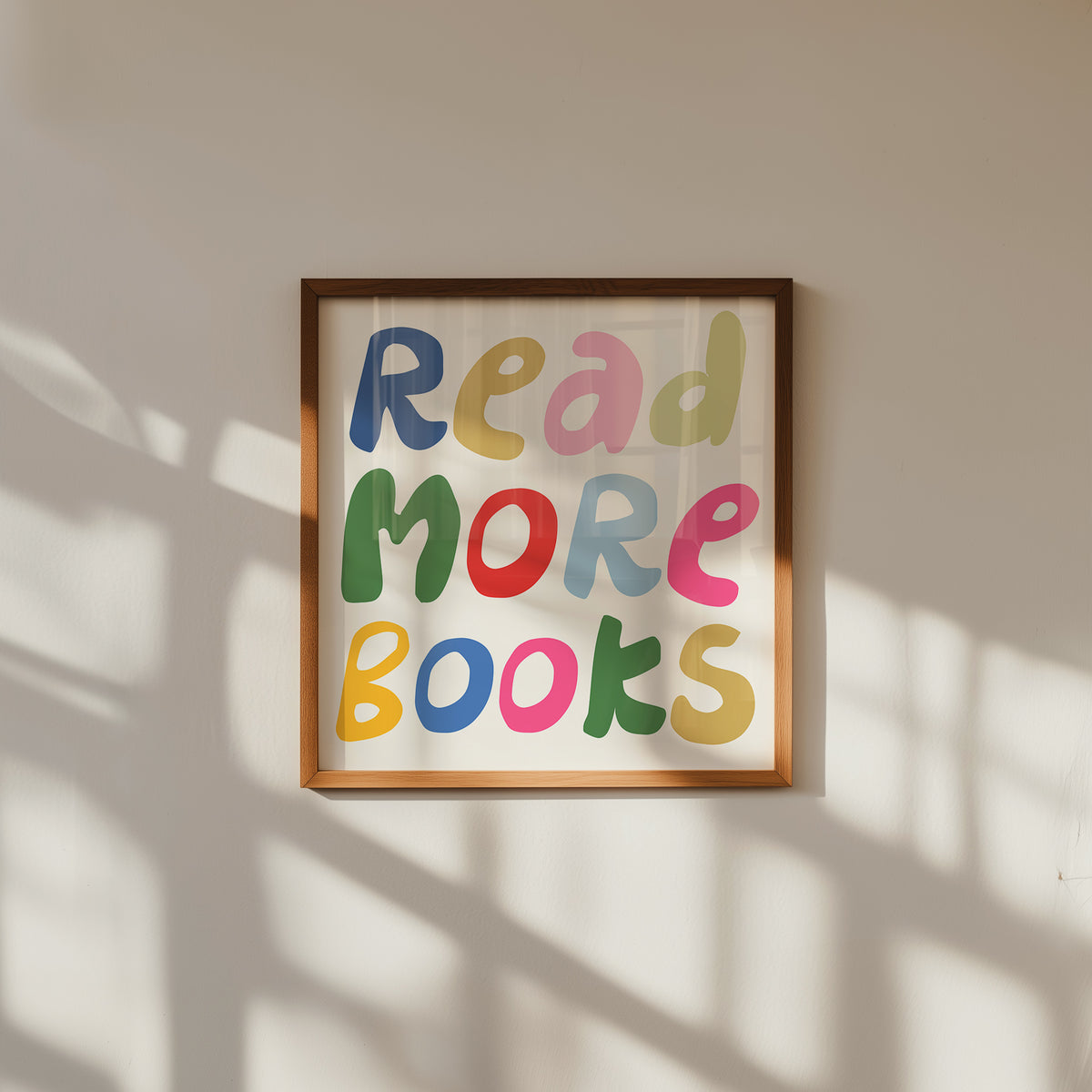 Square print with the words "Read More Books" in large multicolored bubble letters — blue, yellow, pink, green, red, and orange — stacked on three lines against a cream background.