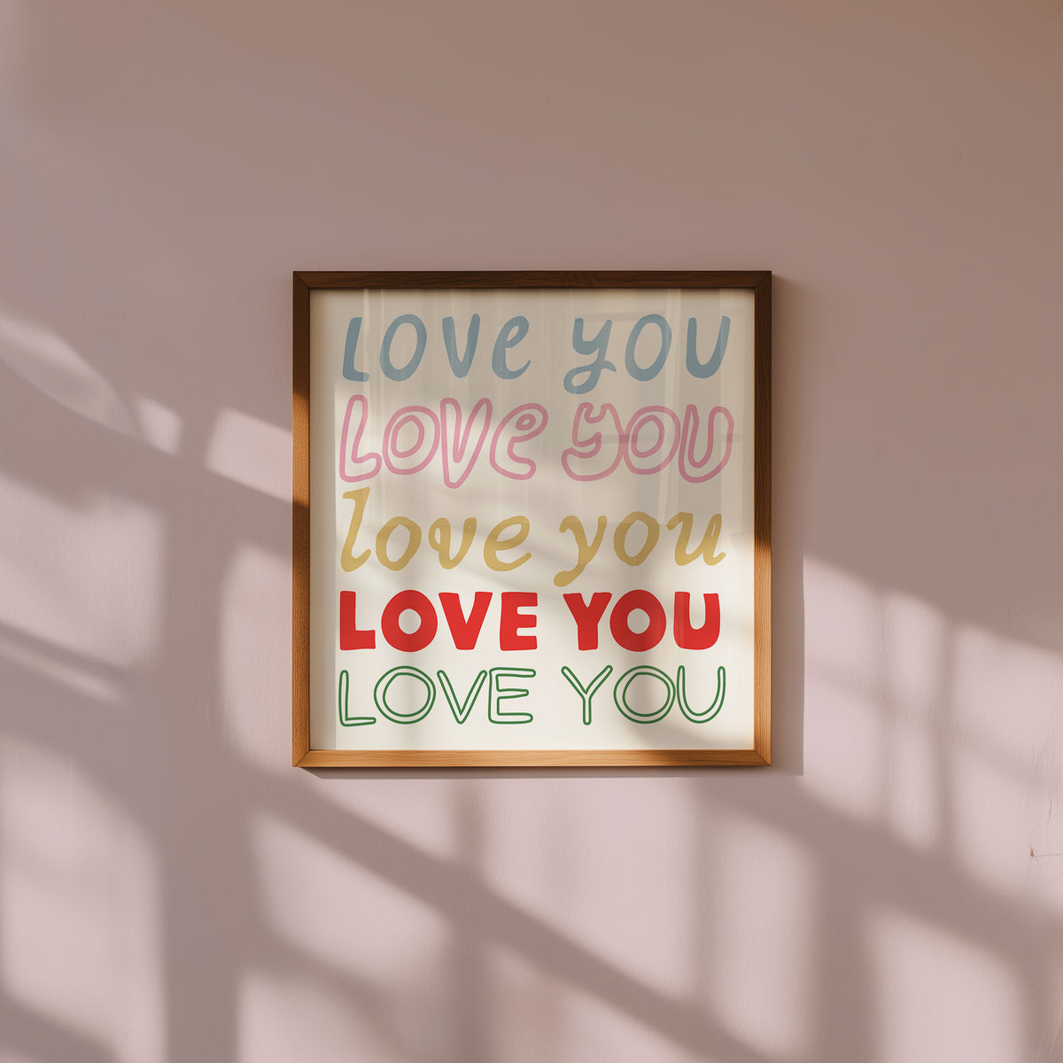 Square print with the words "Love You" repeated five times in different colors, fonts, and styles — blue, pink, gold, red, and green — stacked on a cream background.