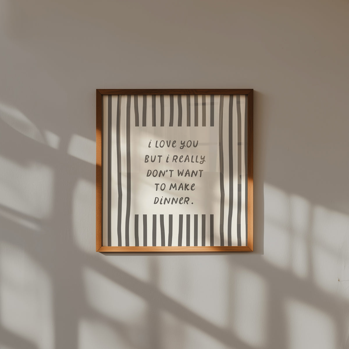 Square print with bold black and white vertical stripes framing the quote "i love you but i really don't want to make dinner" in dark gray block lettering.