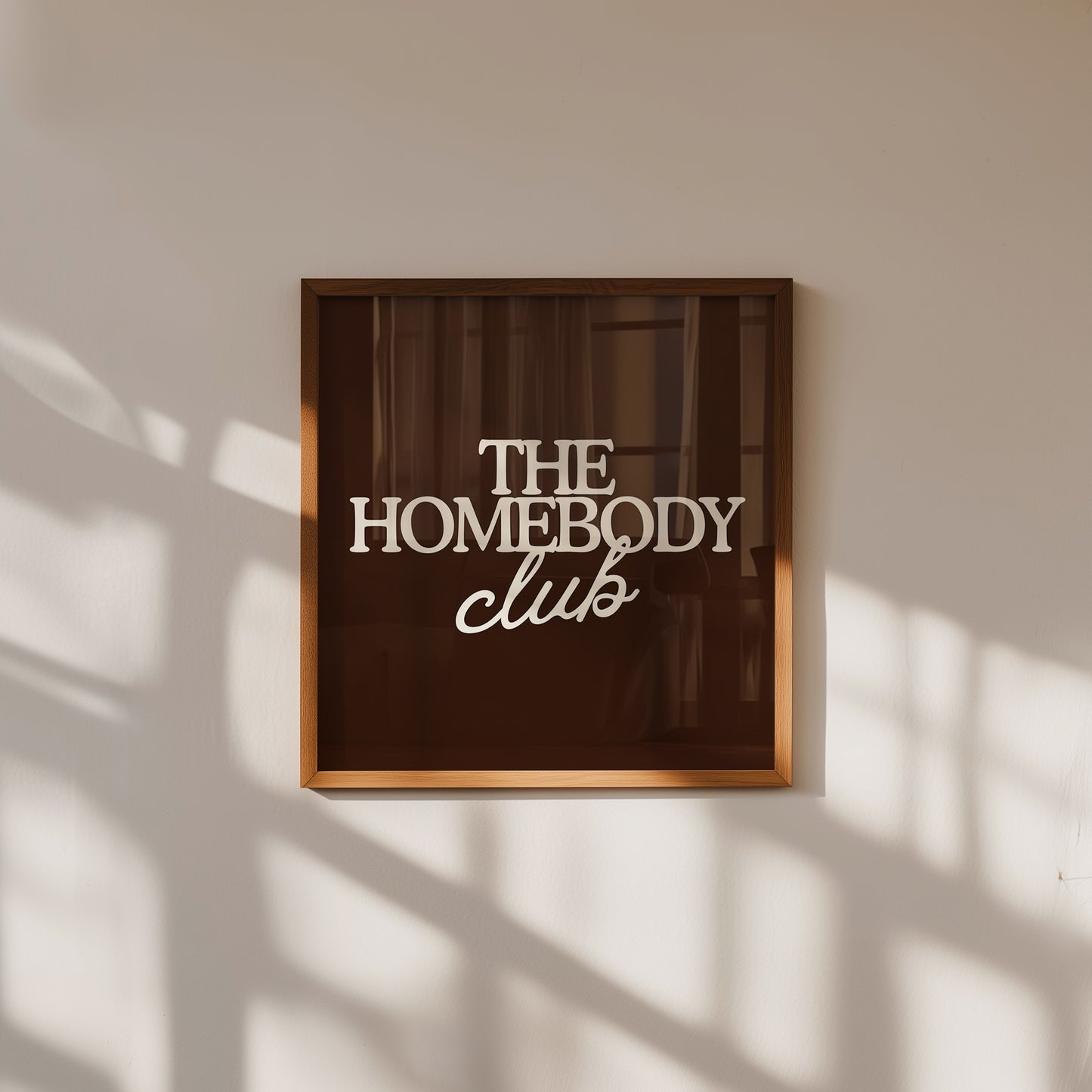 Dark brown print with "The Homebody Club" in bold cream serif and script typography