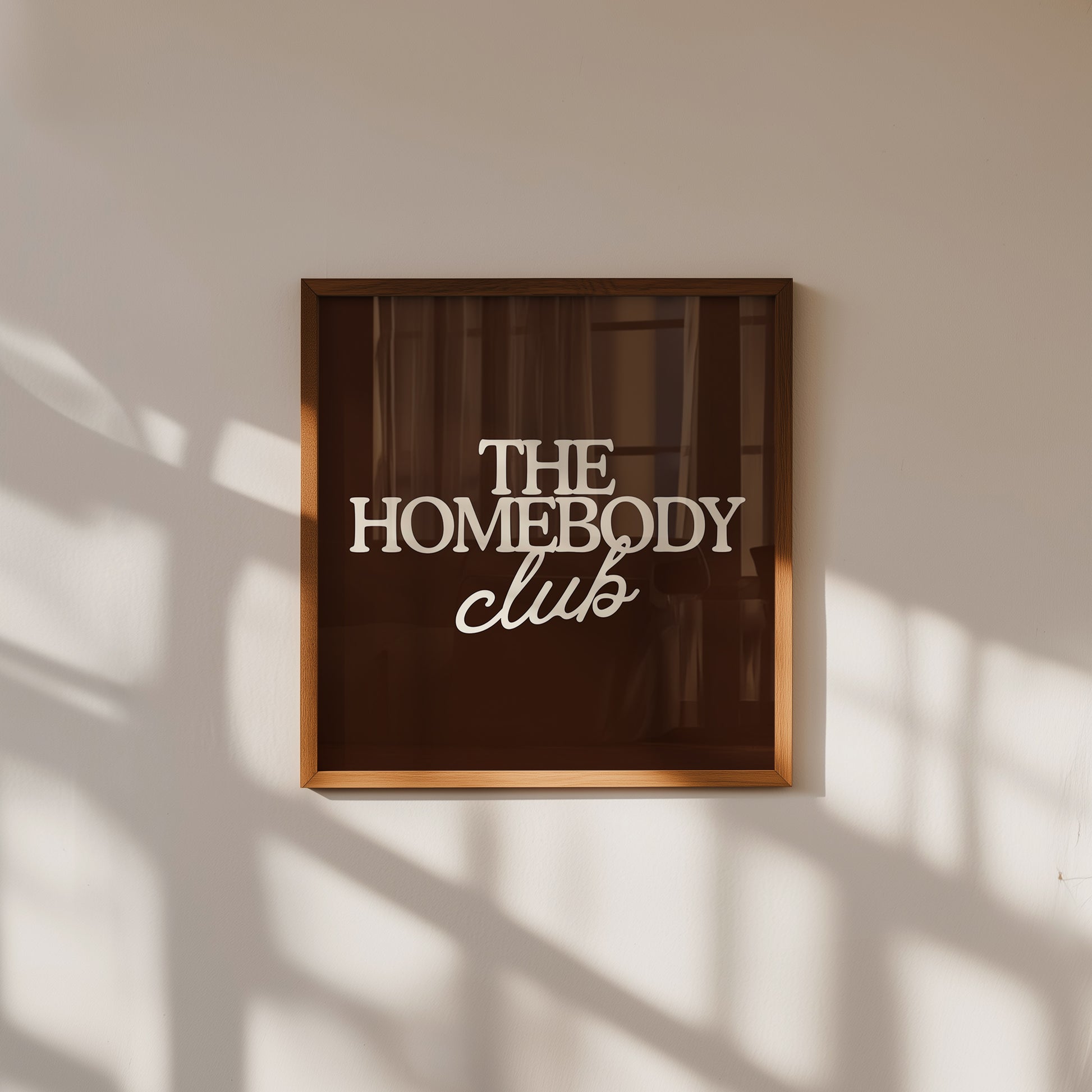 Dark brown print with "The Homebody Club" in bold cream serif and script typography