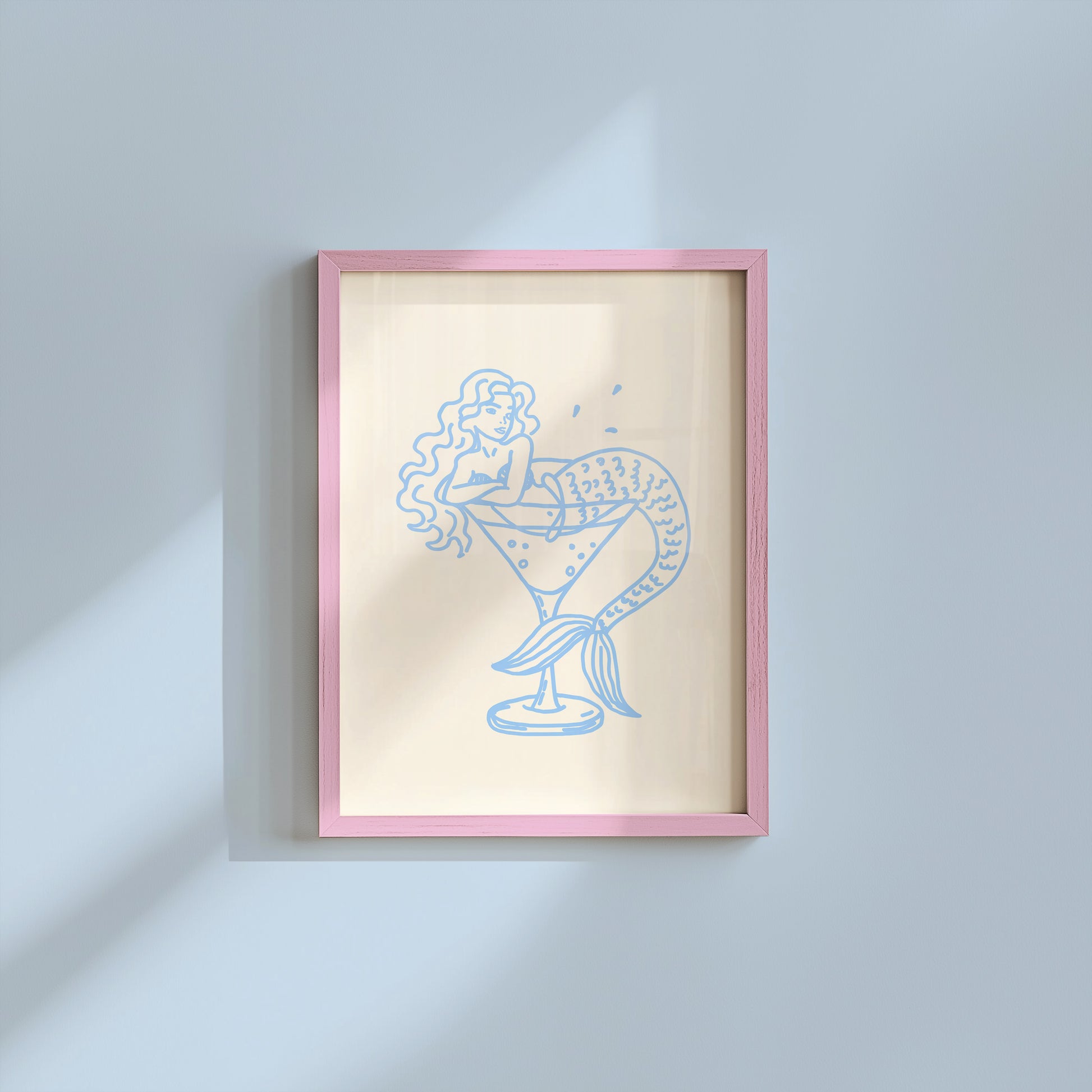 Set of 10 coastal watercolor prints in pink and blue: "Wild Like the Sea" beside a spiral shell illustration, "Stay Wild Ocean Child" in bold blue lettering, "Sea La Vie" in pink stamped typography, a mermaid lounging in a martini glass, pink starfish and seashell illustrations, a woman in a shell headdress, a beach umbrella watercolor, and "Meet me by the sea" in postcard-style script.