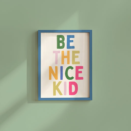 Vertical print with the words "BE THE NICE KID" stacked in large multicolored bubble letters on a cream background in a blue frame.