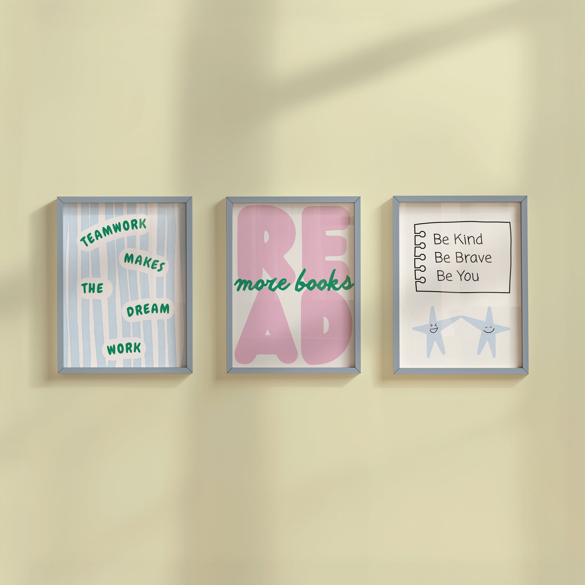 Set of 3 pastel classroom prints: "Teamwork makes the dream work" in green lettering on blue stripes, "READ more books" in pink bubble letters with green script, and "Be Kind Be Brave Be You" on a hand-drawn notebook page above two smiling star characters holding hands.