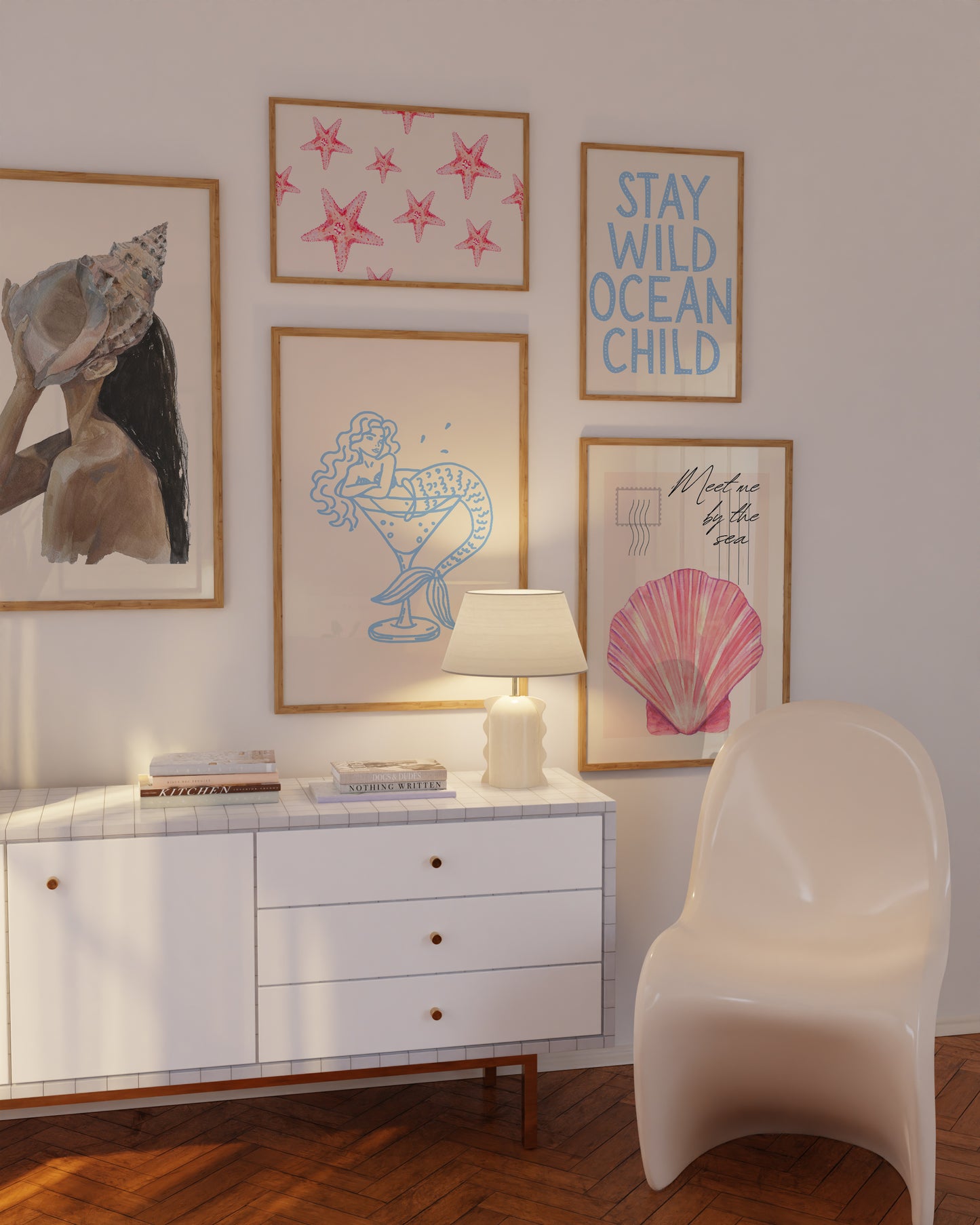 Set of 10 coastal watercolor prints in pink and blue: "Wild Like the Sea" beside a spiral shell illustration, "Stay Wild Ocean Child" in bold blue lettering, "Sea La Vie" in pink stamped typography, a mermaid lounging in a martini glass, pink starfish and seashell illustrations, a woman in a shell headdress, a beach umbrella watercolor, and "Meet me by the sea" in postcard-style script.
