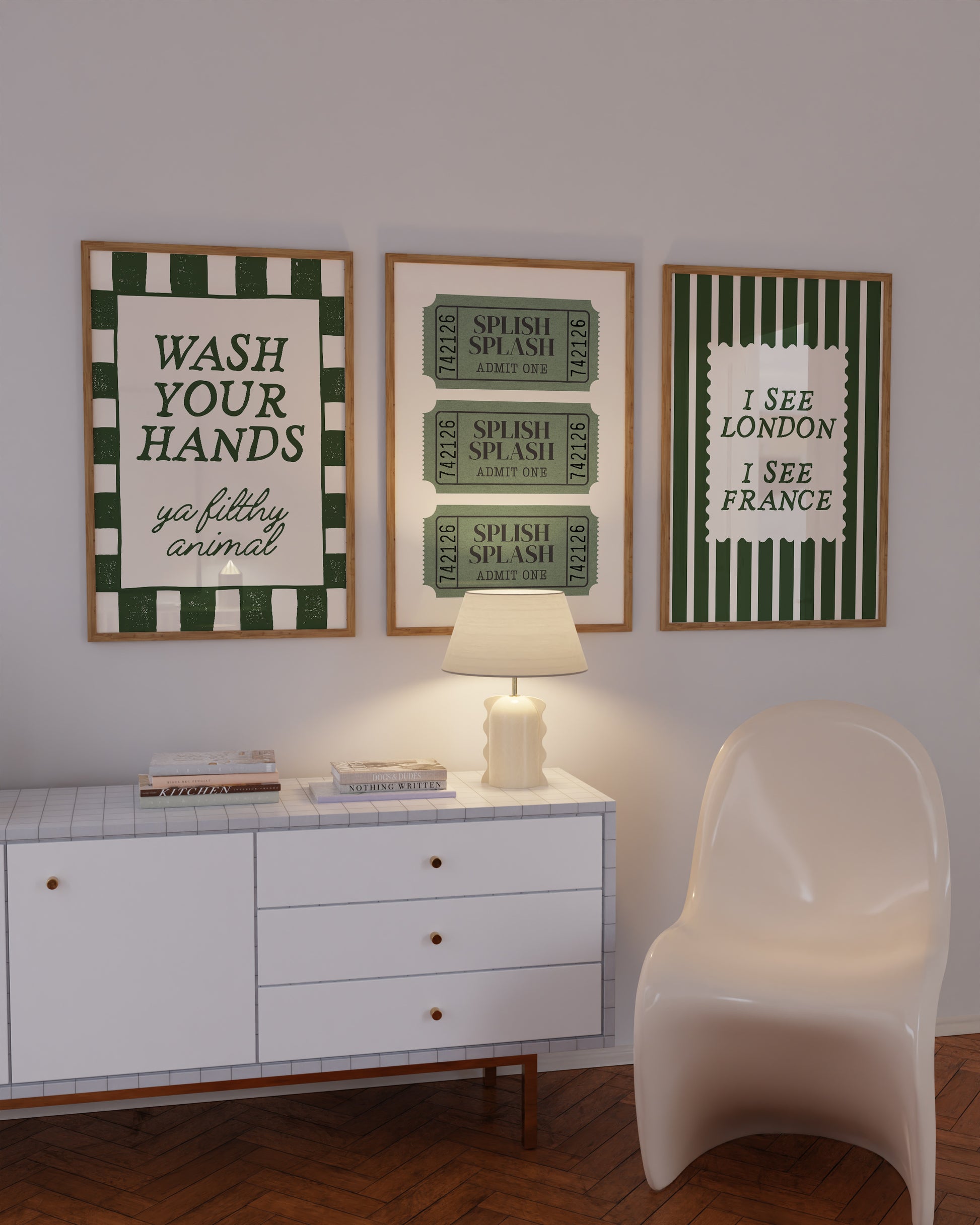 Set of 3 green bathroom prints: "Wash your hands ya filthy animal" in green cursive bordered by a green and cream checkered frame, three green ticket-stub illustrations reading "Splish Splash, Admit One," and "I See London I See France" in a scalloped stamp frame on green and cream stripes.