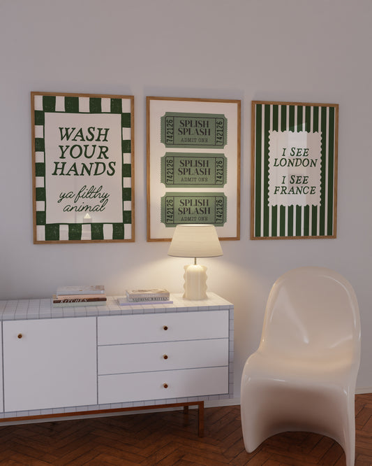 Set of 3 green bathroom prints: "Wash your hands ya filthy animal" in green cursive bordered by a green and cream checkered frame, three green ticket-stub illustrations reading "Splish Splash, Admit One," and "I See London I See France" in a scalloped stamp frame on green and cream stripes.