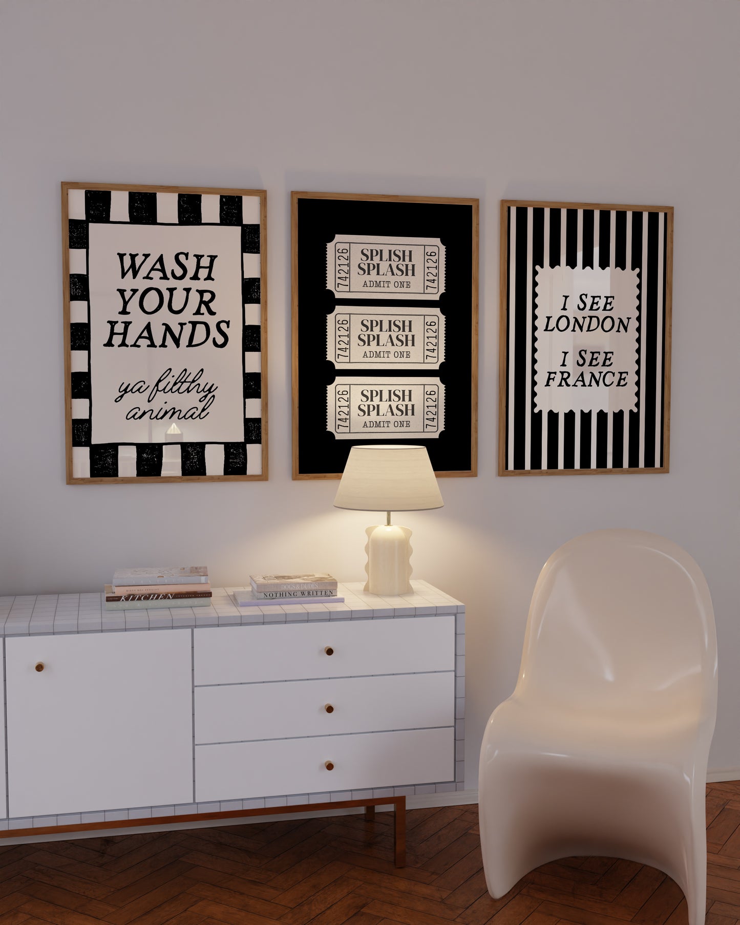Set of 3 black and white bathroom prints: "Wash your hands ya filthy animal" in black cursive bordered by a black and white checkered frame, three black ticket-stub illustrations reading "Splish Splash, Admit One," and "I See London I See France" in a scalloped stamp frame on black and white stripes.