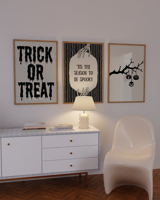 Set of 3 black and white Halloween prints: dripping "Trick or Treat" typography, "'Tis the season to be spooky" framed by skeleton hands, and a black silhouette branch with hanging jack-o'-lanterns.
