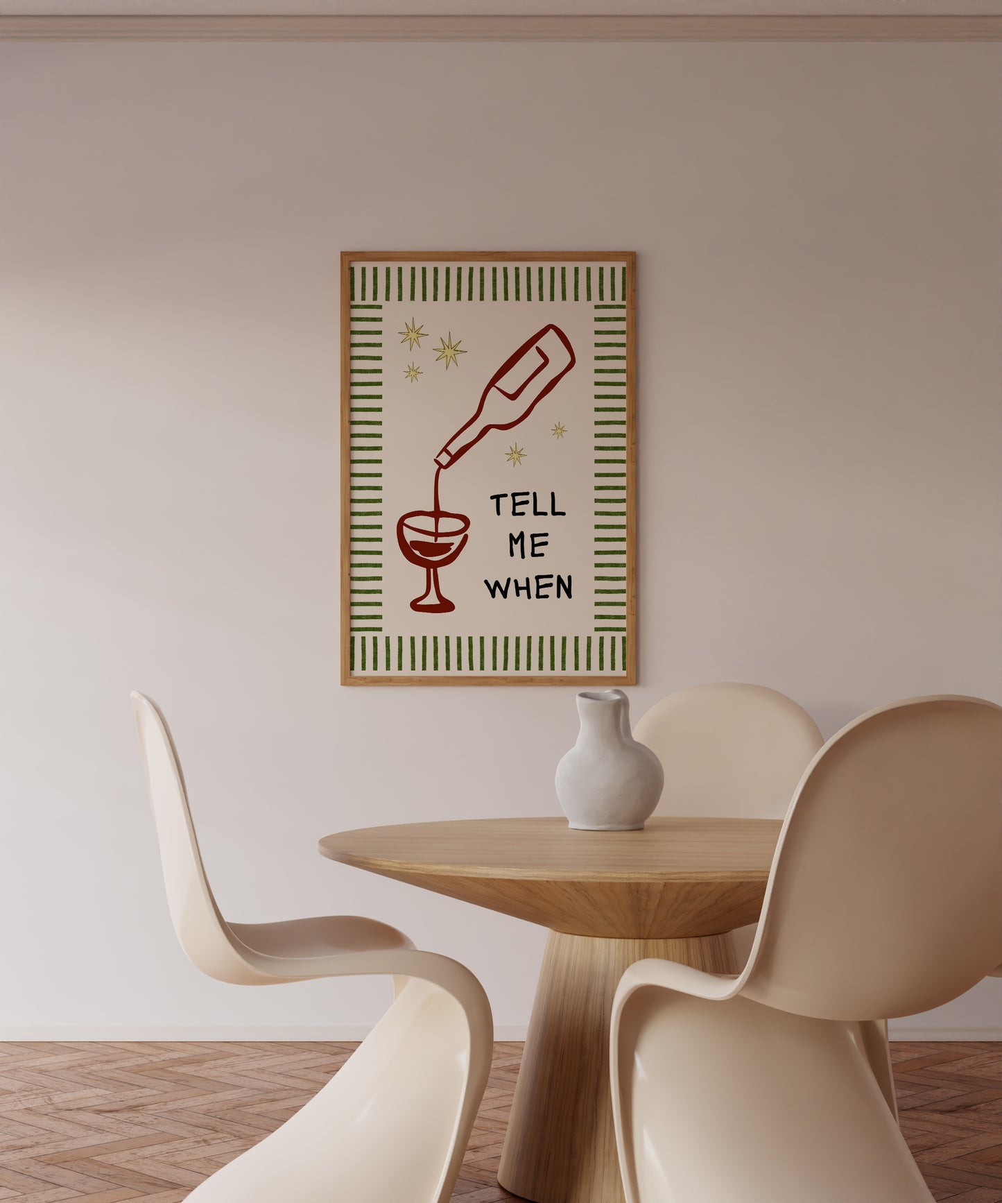 Vertical cream wall print with green stripe border, gold star details, and bold black typography reading Tell Me When alongside dark red hand-drawn line art of a wine bottle pouring into a glass