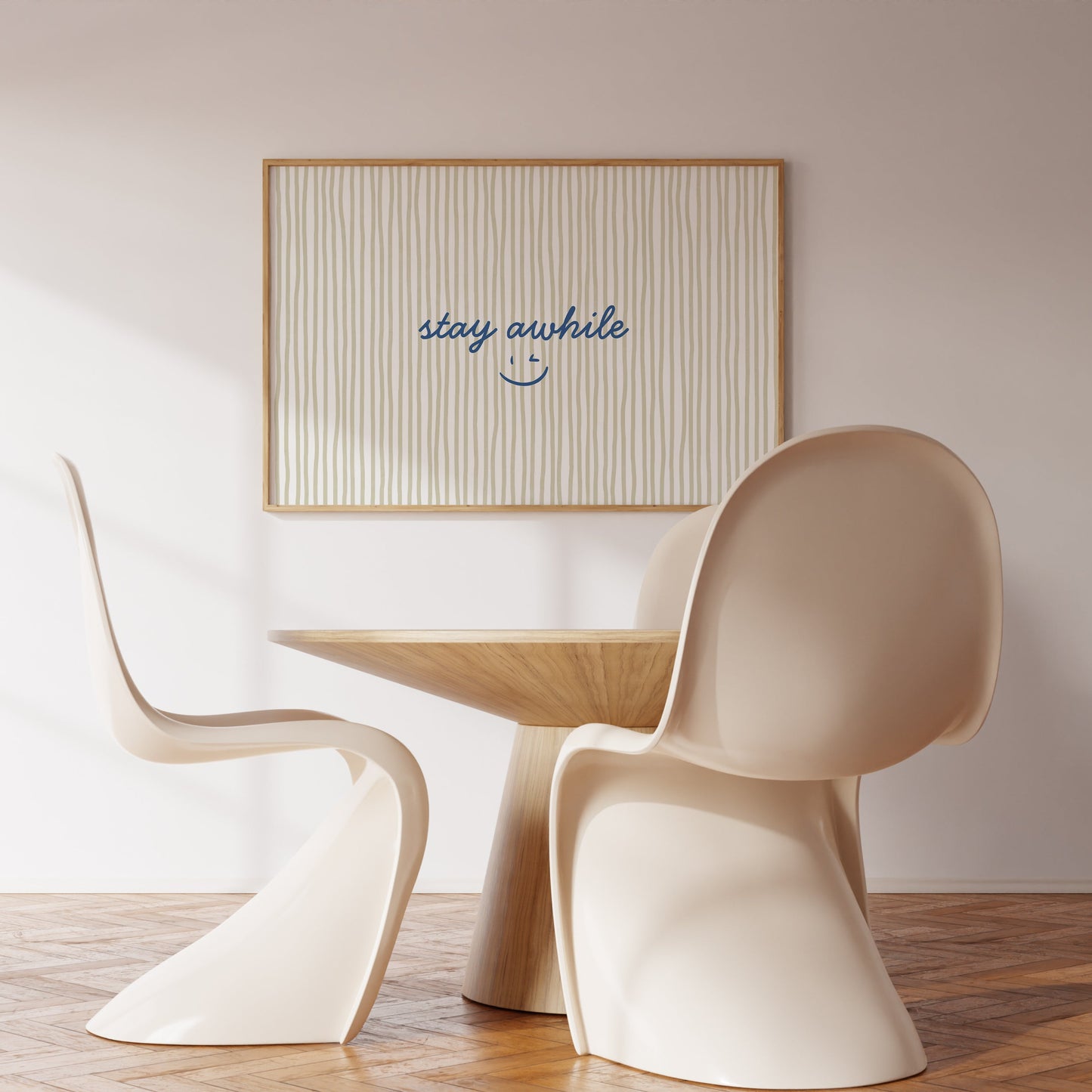 Horizontal print with thin hand-painted tan and cream vertical stripes, the quote "stay awhile" in navy cursive script, and a small hand-drawn smiley face beneath it.