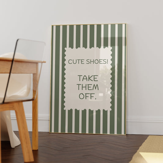 Vertical wall print with bold olive green and cream vertical stripes and a cream scalloped border text box reading Cute Shoes! Take Them Off. in matching green serif typography