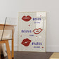 Cream print with three illustrated red lips paired with "Besos," "Bisous," and "Beijos" in navy lettering, with small red hearts scattered throughout