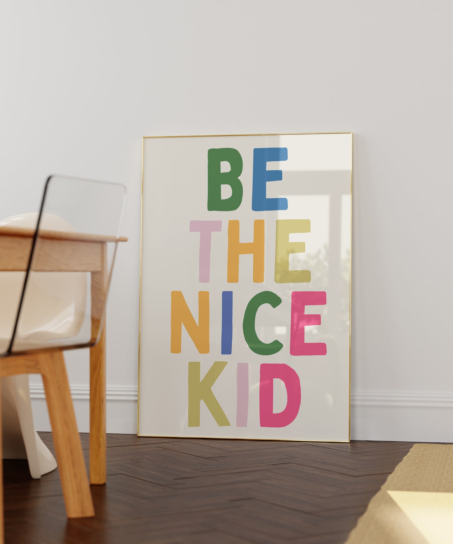 Vertical print with the words "BE THE NICE KID" stacked in large multicolored bubble letters on a cream background in a blue frame.