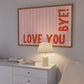 Horizontal wall print with soft pink wavy vertical stripes and bold red rounded typography reading LOVE YOU BYE! in the bottom corner