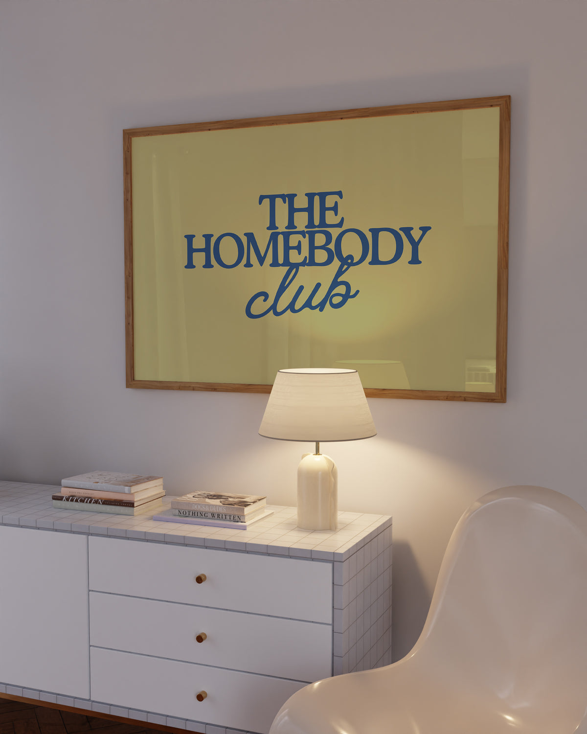 Rectangular landscape digital print with an olive-green background featuring "THE HOMEBODY" in bold blue serif type stacked above "club" in blue cursive script, centered typography layout.
