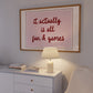 Horizontal wall print with a soft pink centre panel and white border with dark red scalloped outline, bold dark red cursive script reading it actually is all fun & games