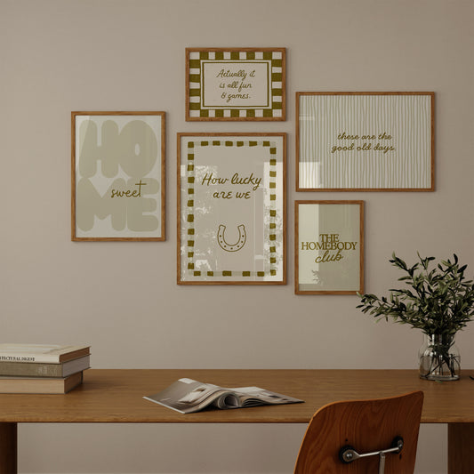 Set of five olive and cream prints including a checkered 'Actually it is all fun & games' print, a horseshoe 'How lucky are we' print, 'The Homebody Club', a striped 'good old days' print, and bubble-letter 'Home sweet'