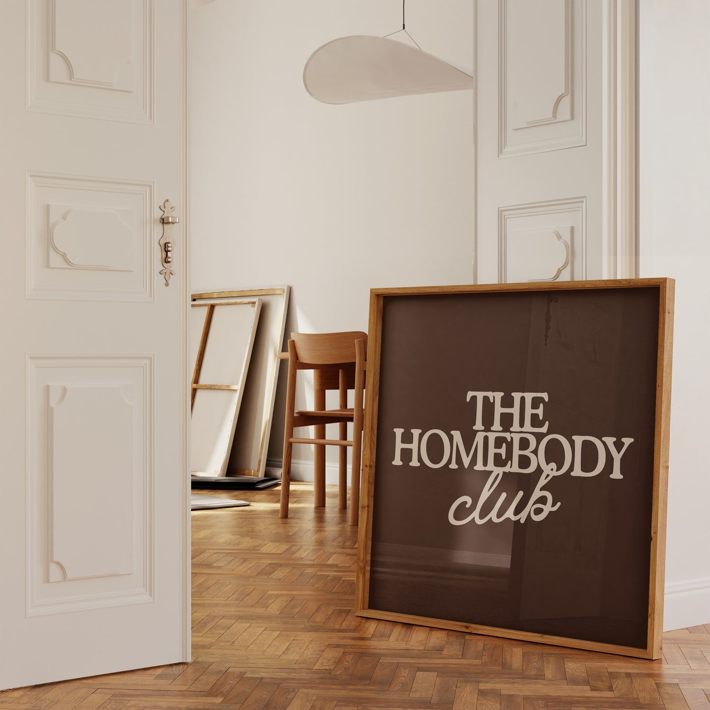 Dark brown print with "The Homebody Club" in bold cream serif and script typography