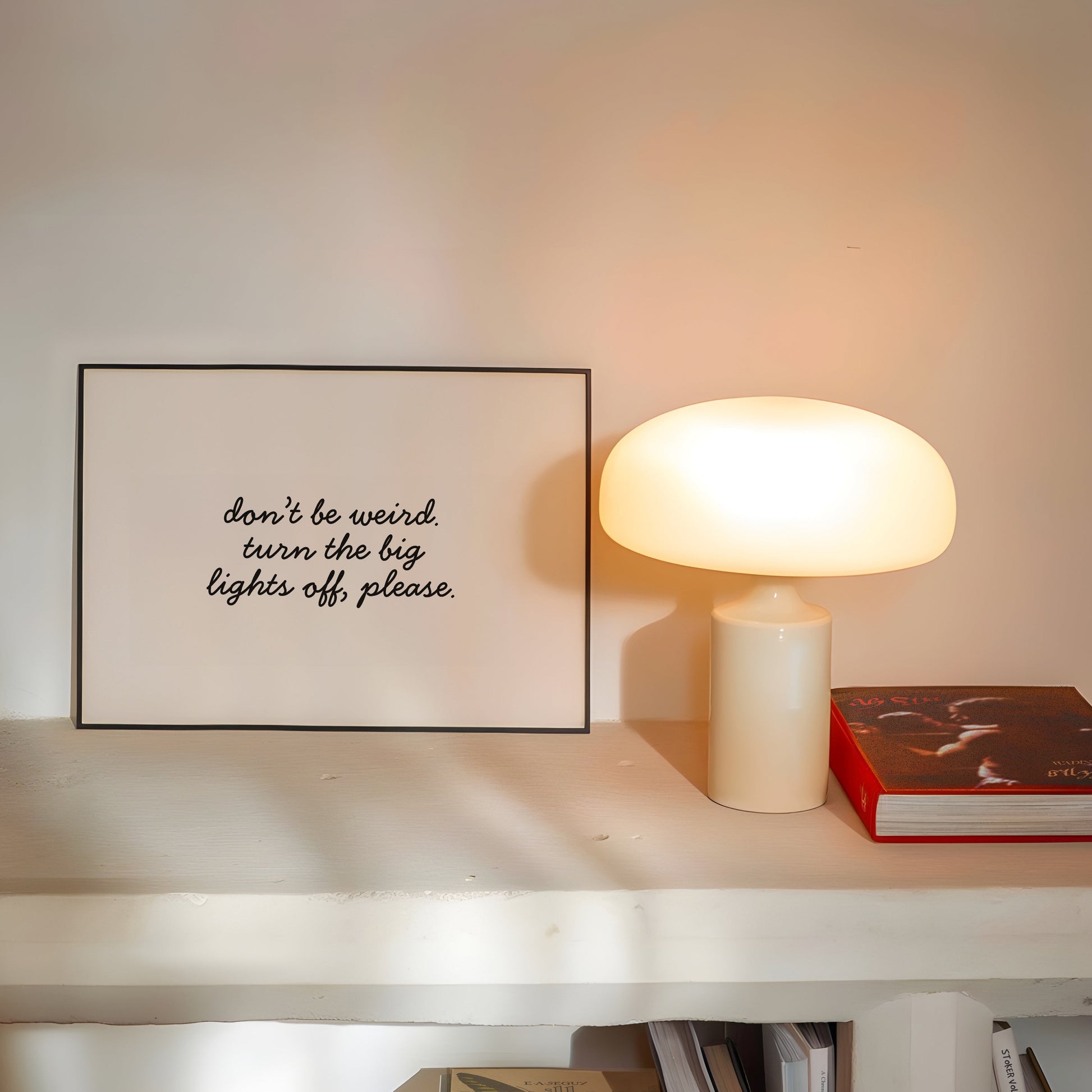 Horizontal white wall print with elegant black cursive script reading don't be weird. turn the big lights off, please.