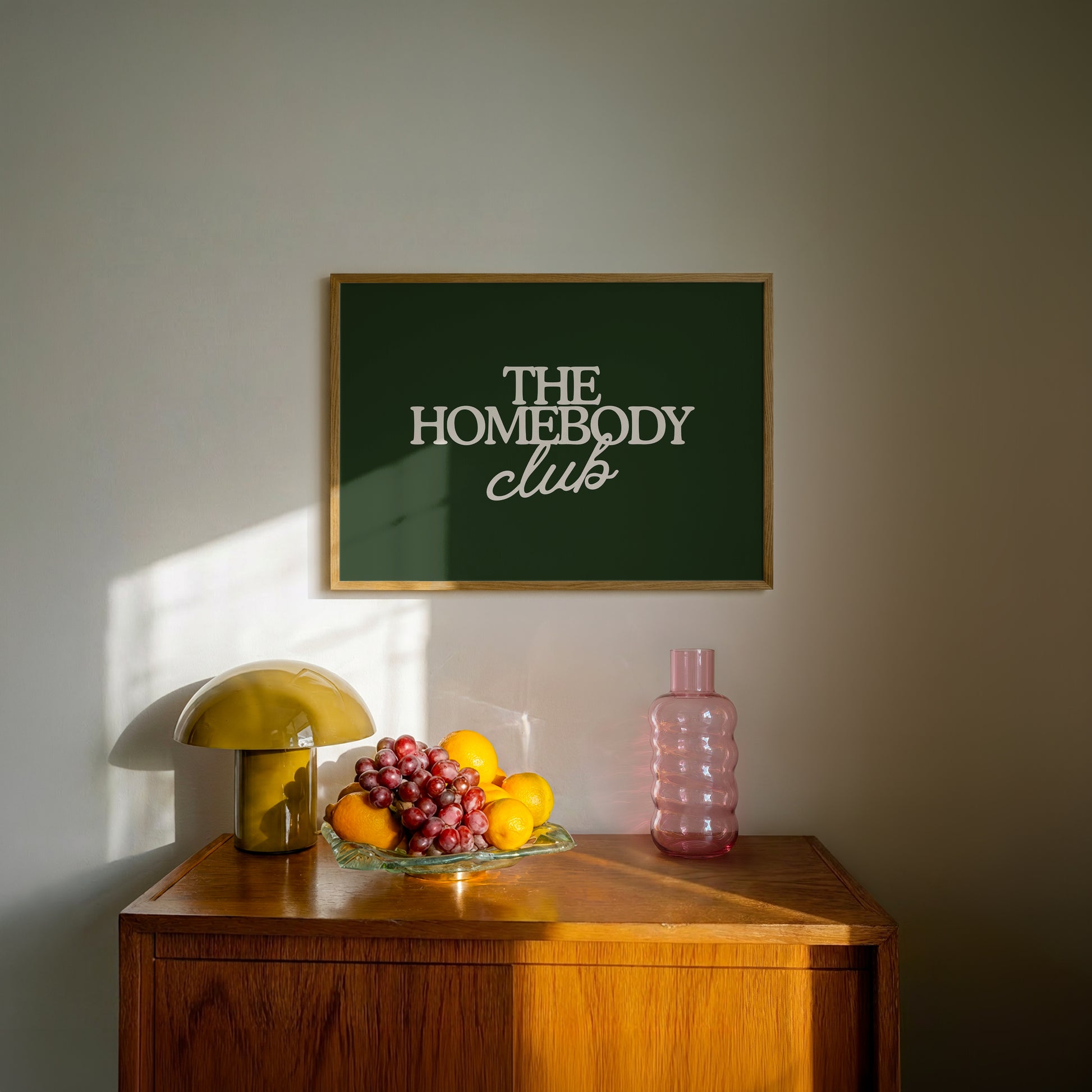 Dark green print with "The Homebody Club" in cream serif and script typography