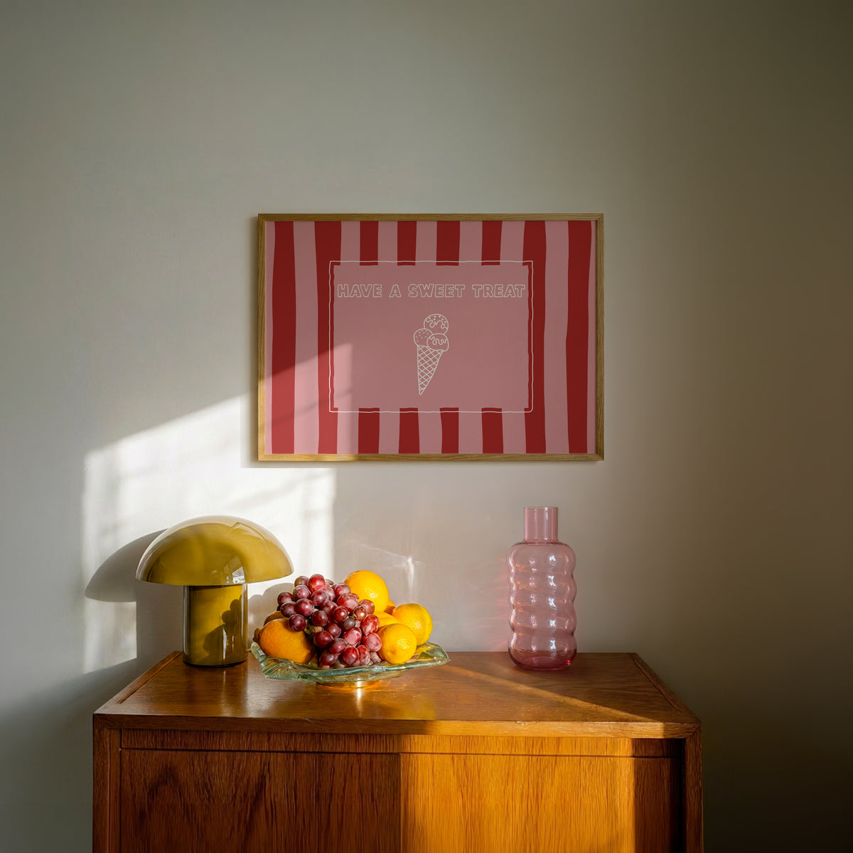 Horizontal print with bold red and pink vertical stripes and a hand-drawn ice cream cone illustration inside a rectangular border, with the words "HAVE A SWEET TREAT" in outlined block lettering.