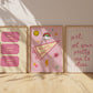 Three pink dorm art prints leaning against wall — Good Times tickets, This Feels Like Home pennant, Girl Get Your Pretty Ass To Class