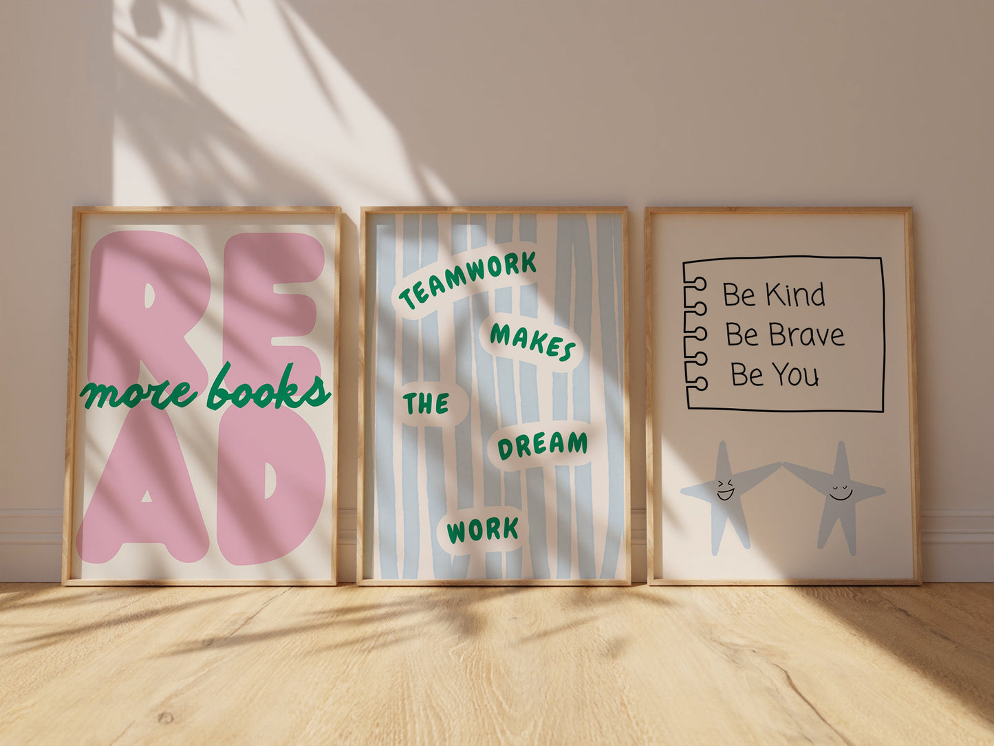 Set of 3 pastel classroom prints: "Teamwork makes the dream work" in green lettering on blue stripes, "READ more books" in pink bubble letters with green script, and "Be Kind Be Brave Be You" on a hand-drawn notebook page above two smiling star characters holding hands.