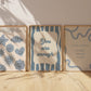 Set of 10 calm corner prints in tan and blue: "Take Your Time," "I am enough" on a smiley face, "Breathe" beside a meditating duck illustration, a "Daily Check-in, All Feelings Welcome!" chart with cartoon stars and clouds, "Slow Down, You're Doing Fine!", "You are enough," "Be Kind To Your Mind" on a checkered background, "This is a Safe Space" on a house shape, "The way you speak to yourself matters" beside a heart illustration, and "It's OK to Not Be OK."