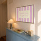 Horizontal art print with hand-painted pink and cream vertical stripes and the quote "Spark joy or get out" in pink cursive script inside a rounded cream panel at the centre.