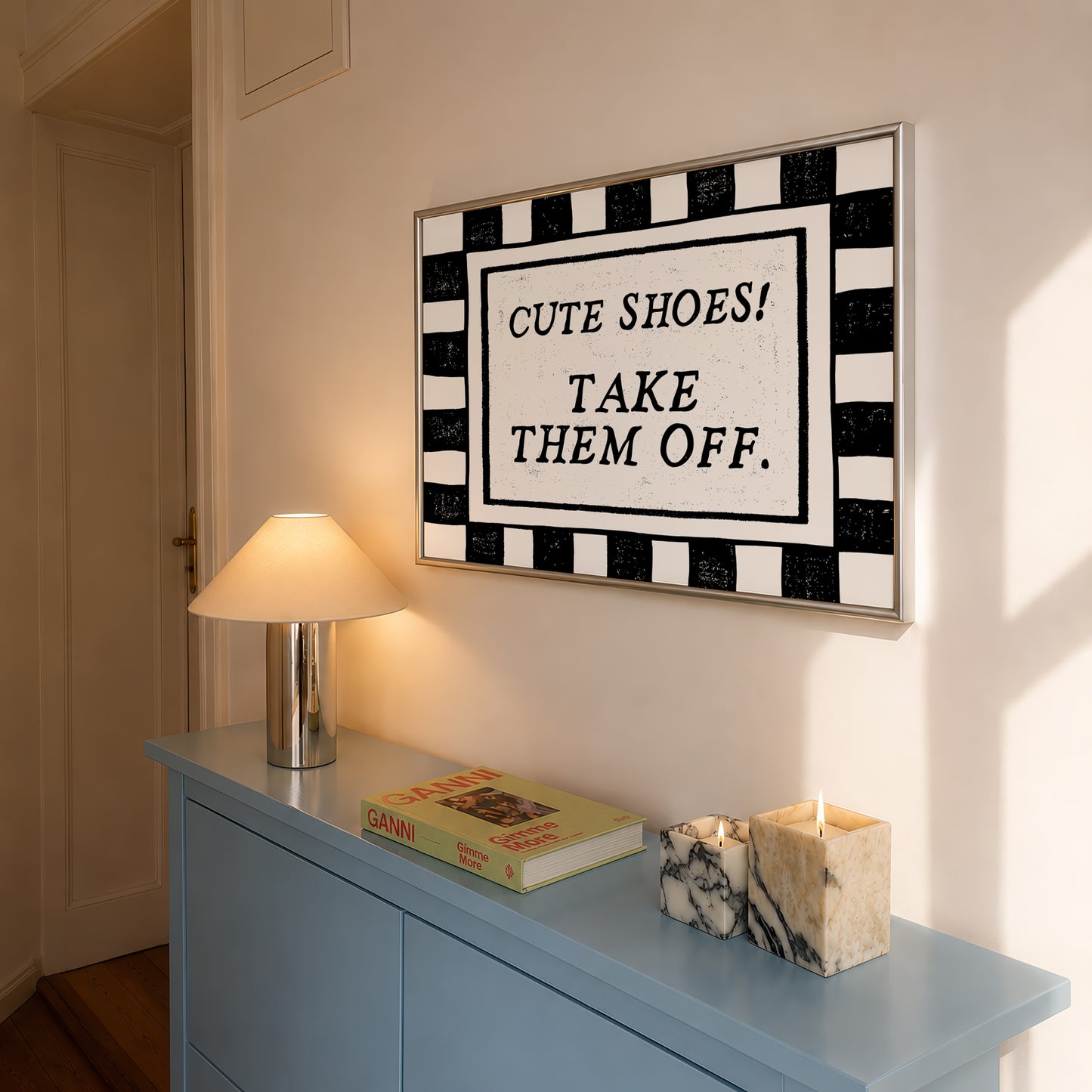 Horizontal print with a bold black and white checkered border framing the quote "CUTE SHOES! TAKE THEM OFF." in black vintage serif type on a cream background.