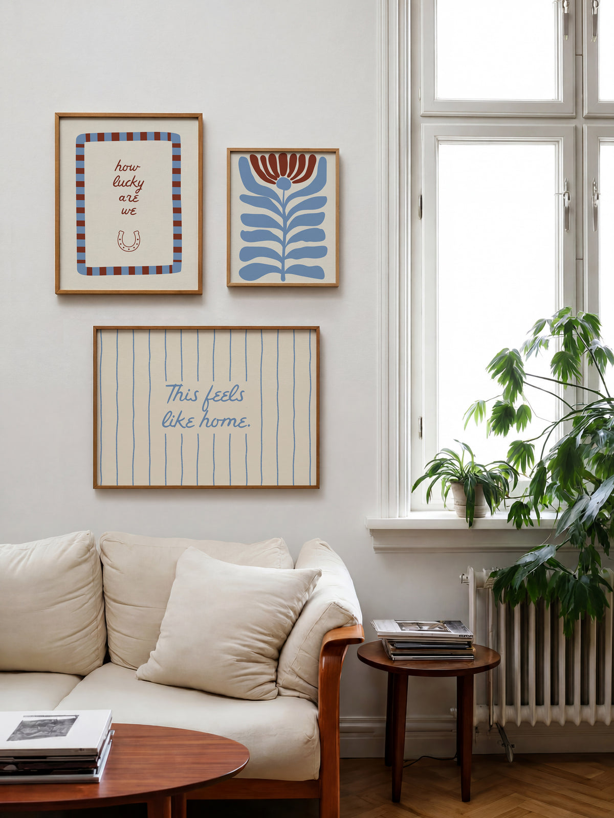 Set of five prints in rust and dusty blue: "How lucky are we" with a horseshoe, "So happy you are here," "What's for dinner?" in a checkered border, "This feels like home" on stripes, and a floral illustration