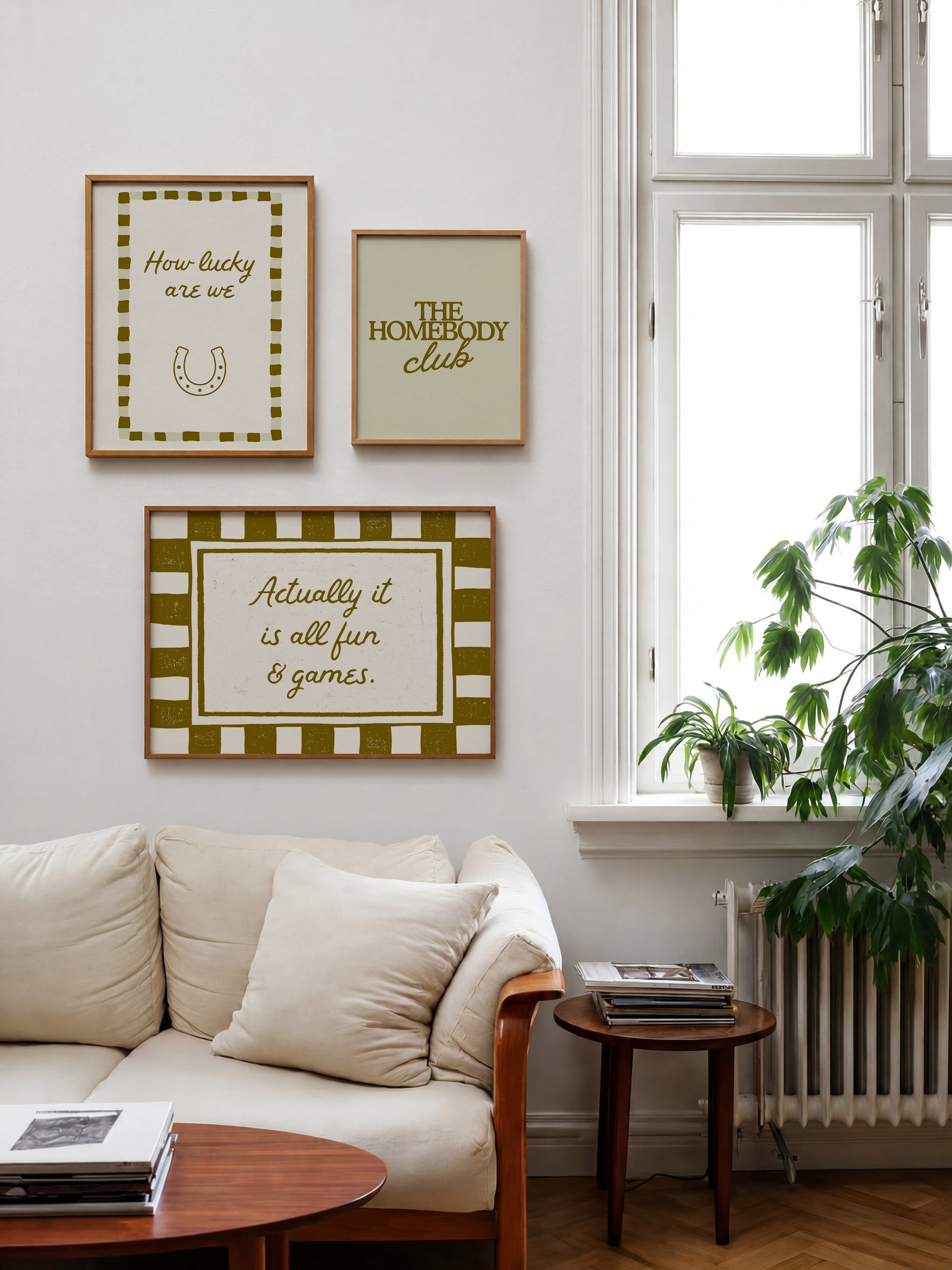 Set of five olive and cream prints including a checkered 'Actually it is all fun & games' print, a horseshoe 'How lucky are we' print, 'The Homebody Club', a striped 'good old days' print, and bubble-letter 'Home sweet'