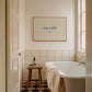 Horizontal print with thin hand-painted tan and cream vertical stripes, the quote "stay awhile" in navy cursive script, and a small hand-drawn smiley face beneath it.