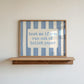 Horizontal wall print with dusty blue vertical brush stripes and a cream rounded text box in retro typewriter font reading text me if you run out of toilet paper
