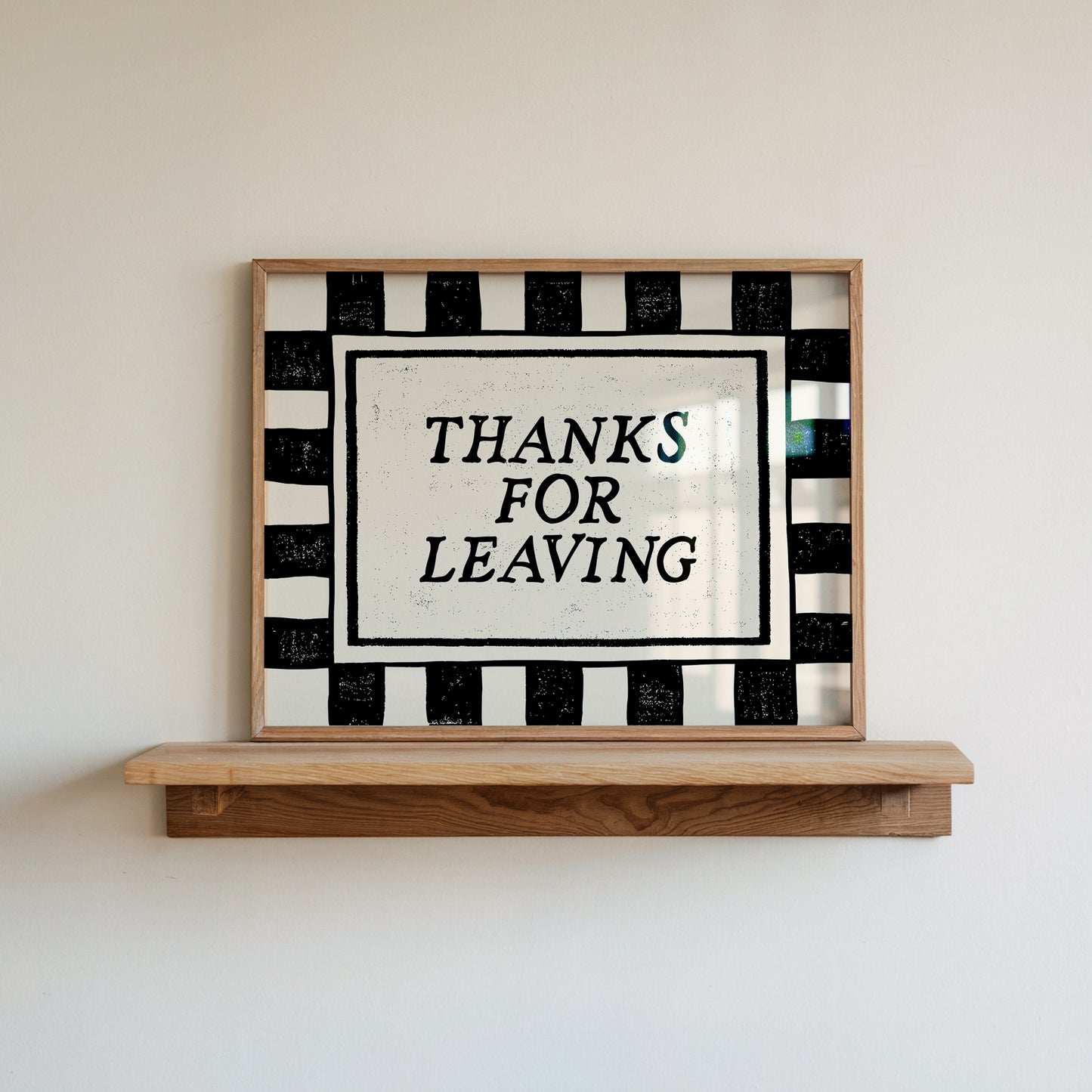 Horizontal wall print with bold black and cream vertical stripes forming a border around a cream text box with distressed black serif typography reading THANKS FOR LEAVING
