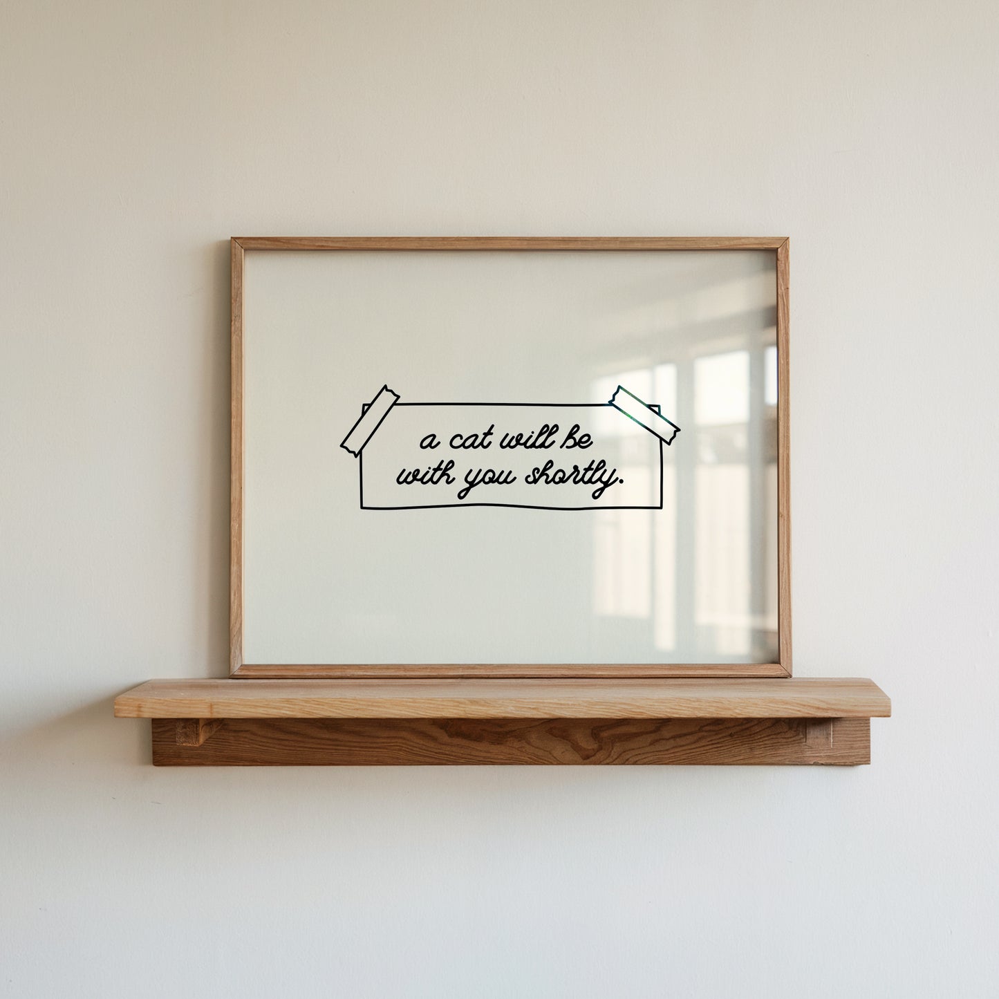 Horizontal wall print on a white background with a hand-drawn taped note in cursive script reading a cat will be with you shortly