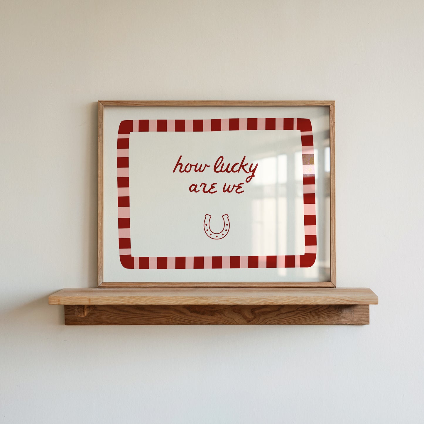 White print with a red and pink striped border featuring the handwritten quote 'how lucky are we' and a horseshoe illustration