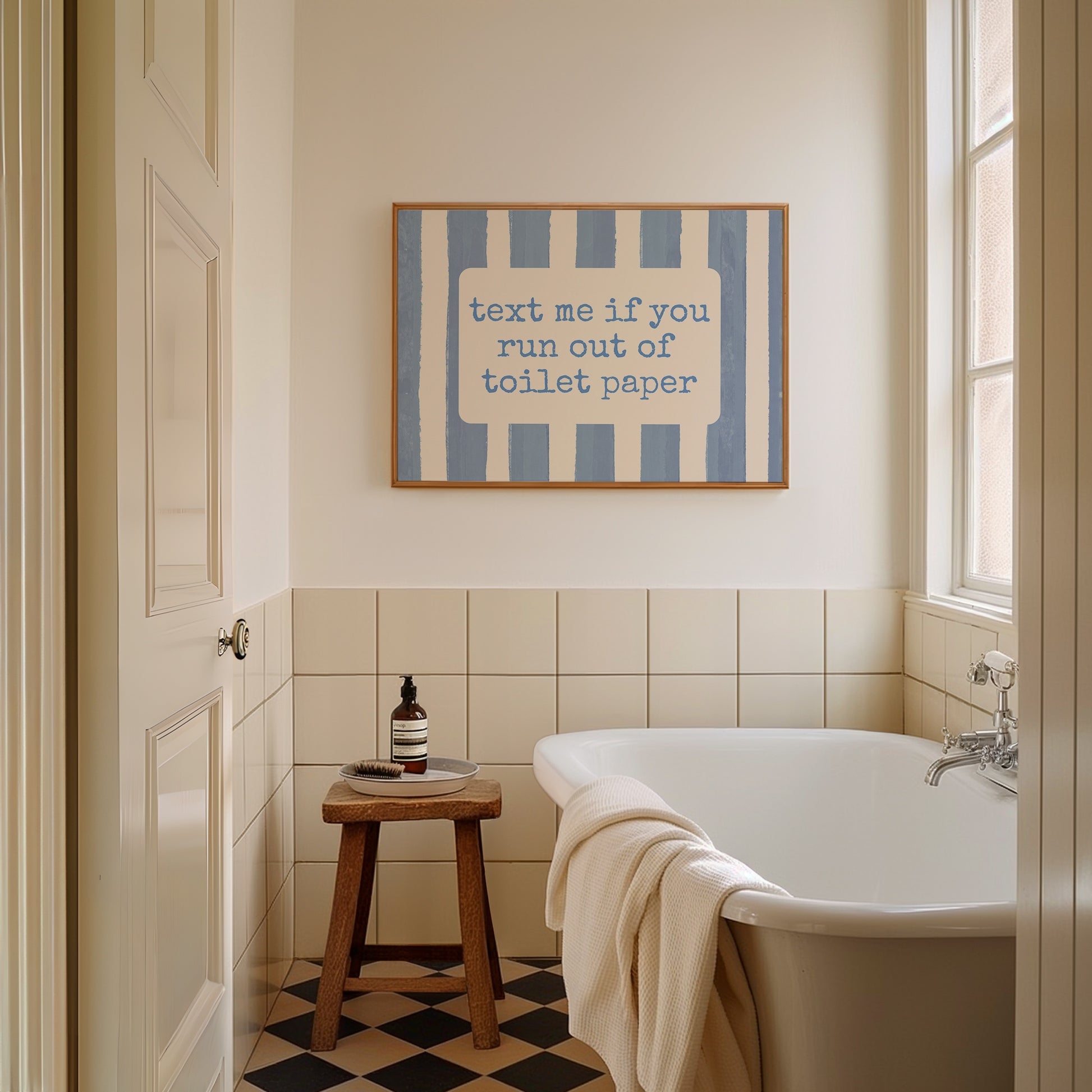 Horizontal wall print with dusty blue vertical brush stripes and a cream rounded text box in retro typewriter font reading text me if you run out of toilet paper