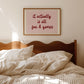Horizontal wall print with a soft pink centre panel and white border with dark red scalloped outline, bold dark red cursive script reading it actually is all fun & games