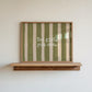Horizontal wall print with bold olive green brush stroke vertical stripes on a warm cream background with white typewriter font text reading Yes girl, you can.