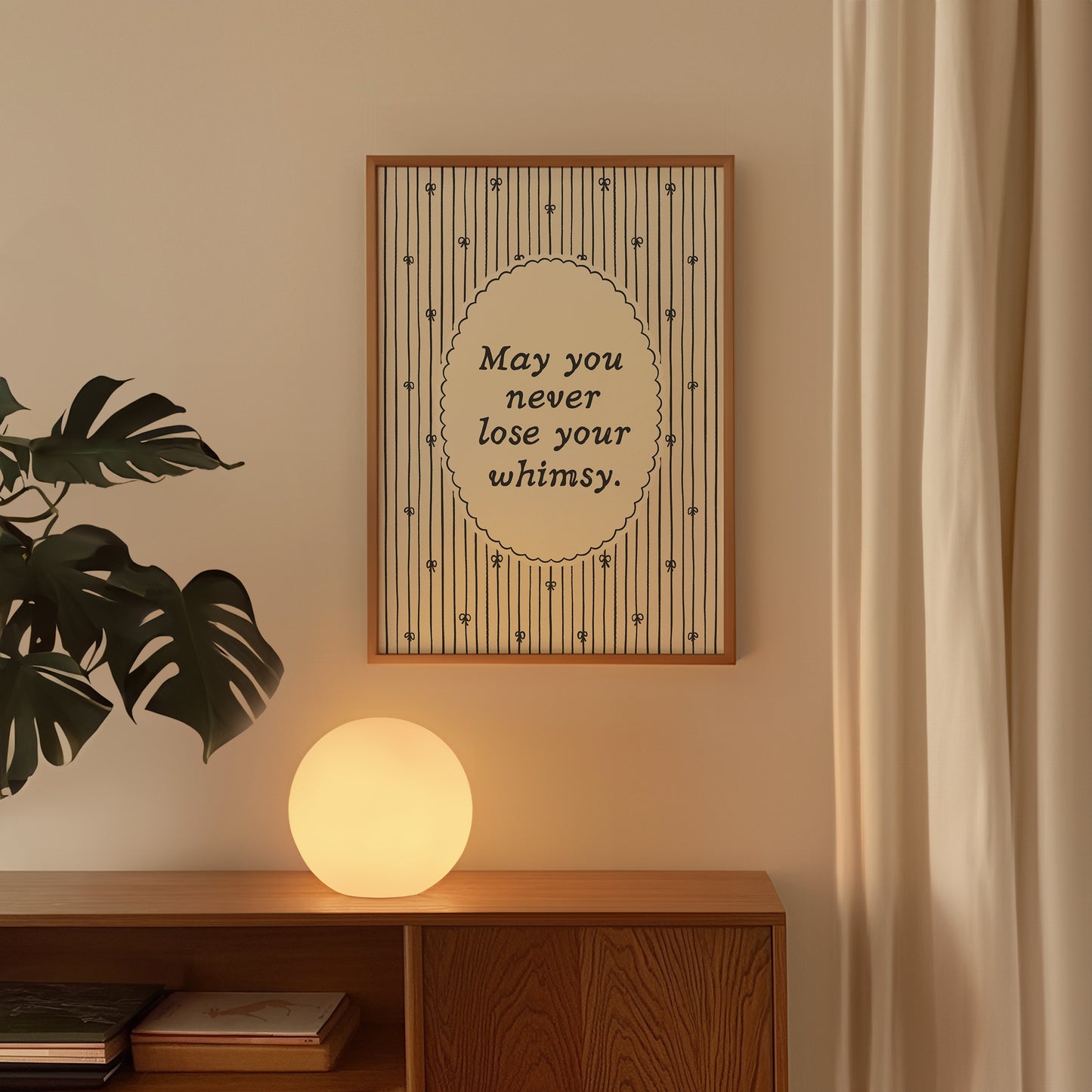 Vertical print with the quote "May you never lose your whimsy." in italic serif type inside a scalloped oval frame, surrounded by thin navy pinstripes decorated with small hand-drawn bows on a cream background.