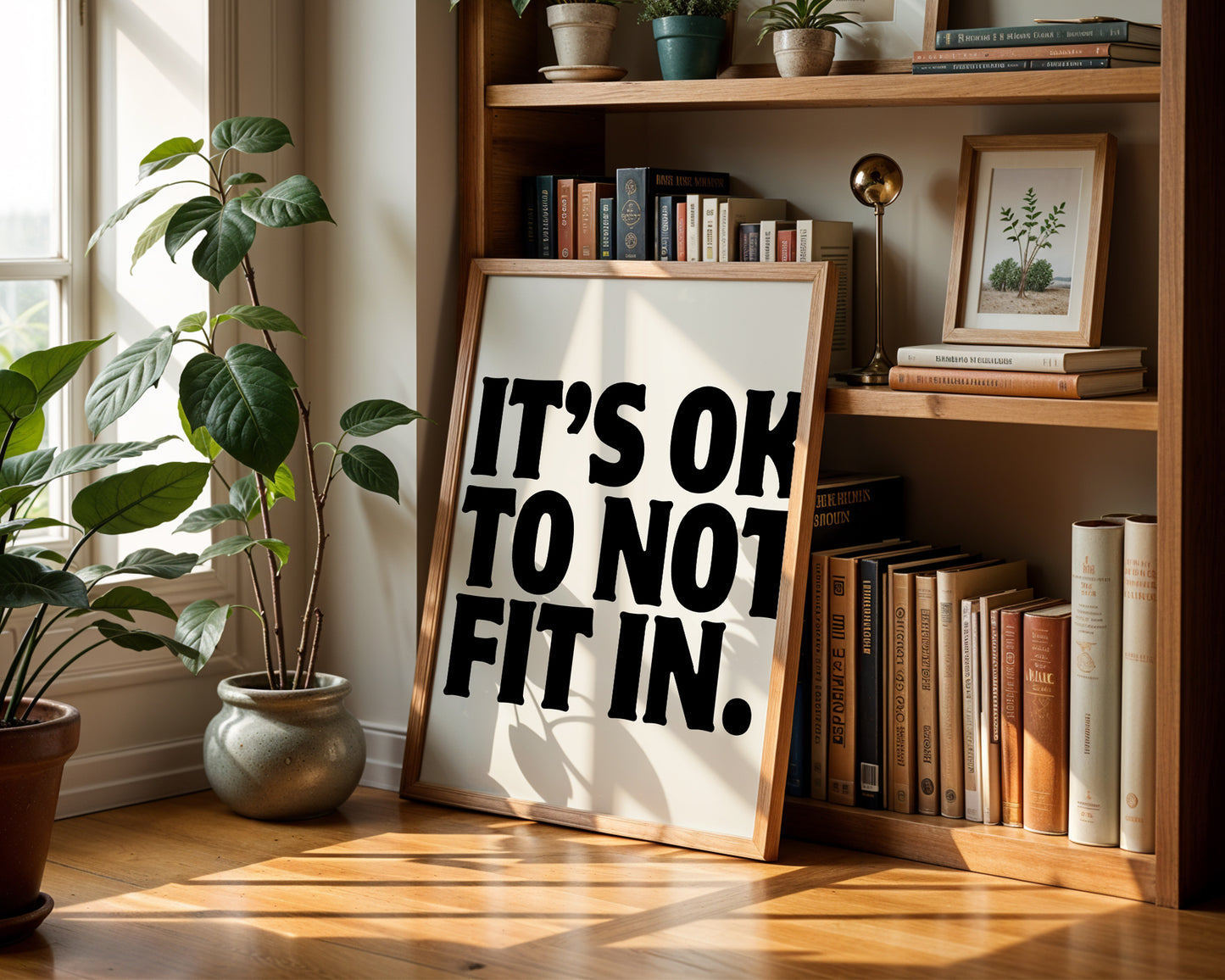 Square cream wall print with bold oversized black chunky typography reading It's Ok To Not Fit In on a clean white background