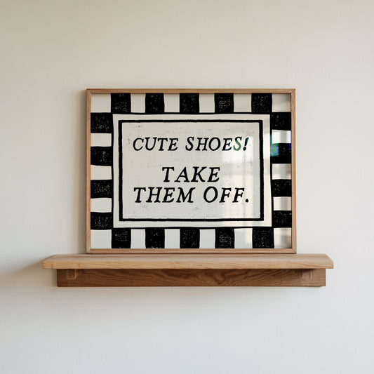 Horizontal print with a bold black and white checkered border framing the quote "CUTE SHOES! TAKE THEM OFF." in black vintage serif type on a cream background.