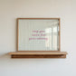 Horizontal wall print with soft sage green wavy vertical stripes and delicate pink cursive script reading may you never lose your whimsy on a warm cream background