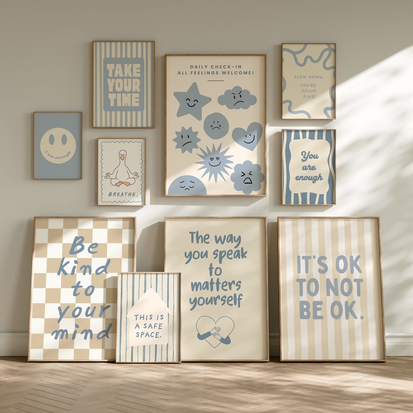 Set of 10 calm corner prints in tan and blue: "Take Your Time," "I am enough" on a smiley face, "Breathe" beside a meditating duck illustration, a "Daily Check-in, All Feelings Welcome!" chart with cartoon stars and clouds, "Slow Down, You're Doing Fine!", "You are enough," "Be Kind To Your Mind" on a checkered background, "This is a Safe Space" on a house shape, "The way you speak to yourself matters" beside a heart illustration, and "It's OK to Not Be OK."
