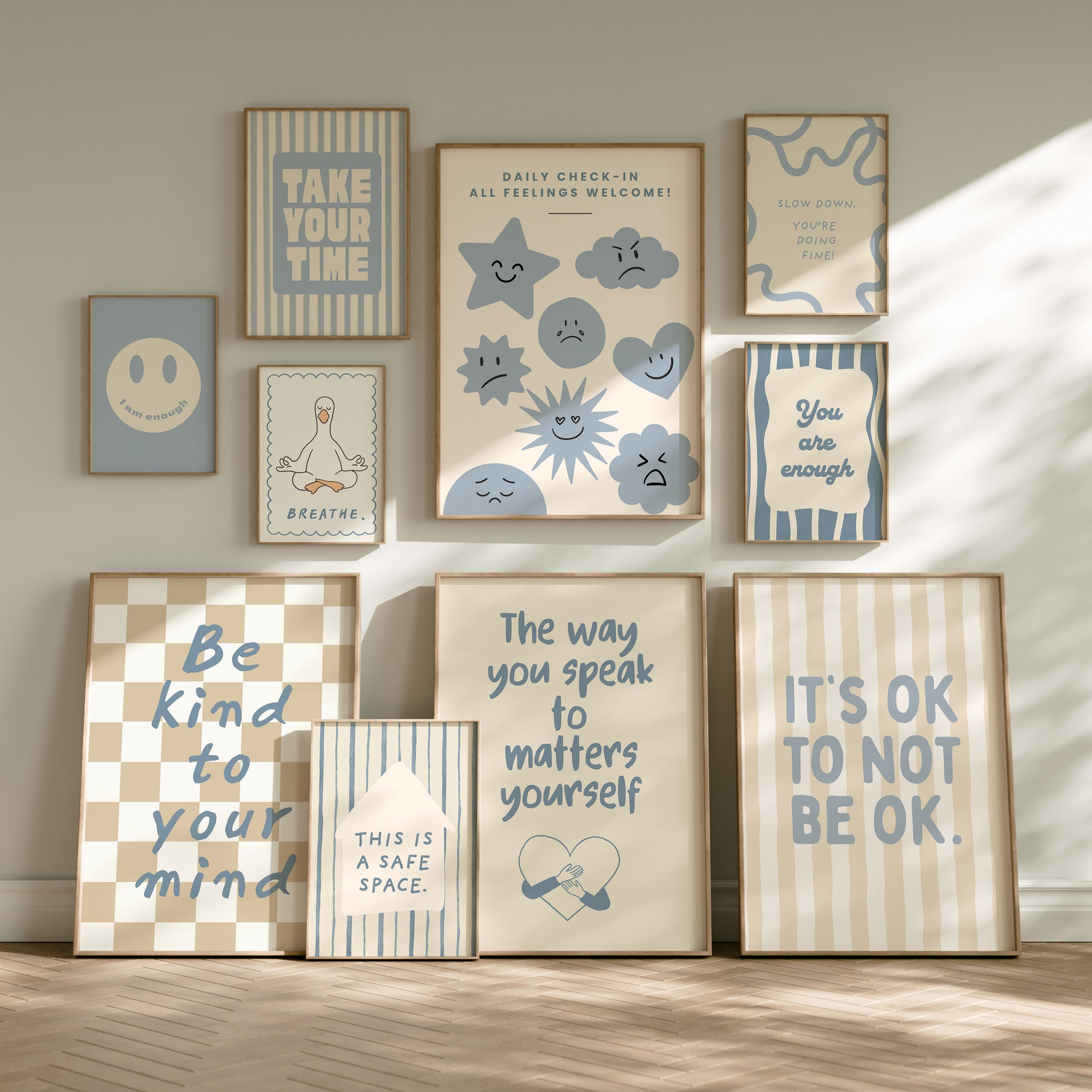 Set of 10 calm corner prints in tan and blue: "Take Your Time," "I am enough" on a smiley face, "Breathe" beside a meditating duck illustration, a "Daily Check-in, All Feelings Welcome!" chart with cartoon stars and clouds, "Slow Down, You're Doing Fine!", "You are enough," "Be Kind To Your Mind" on a checkered background, "This is a Safe Space" on a house shape, "The way you speak to yourself matters" beside a heart illustration, and "It's OK to Not Be OK."