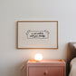 Horizontal wall print on a white background with a hand-drawn taped note in cursive script reading a cat will be with you shortly